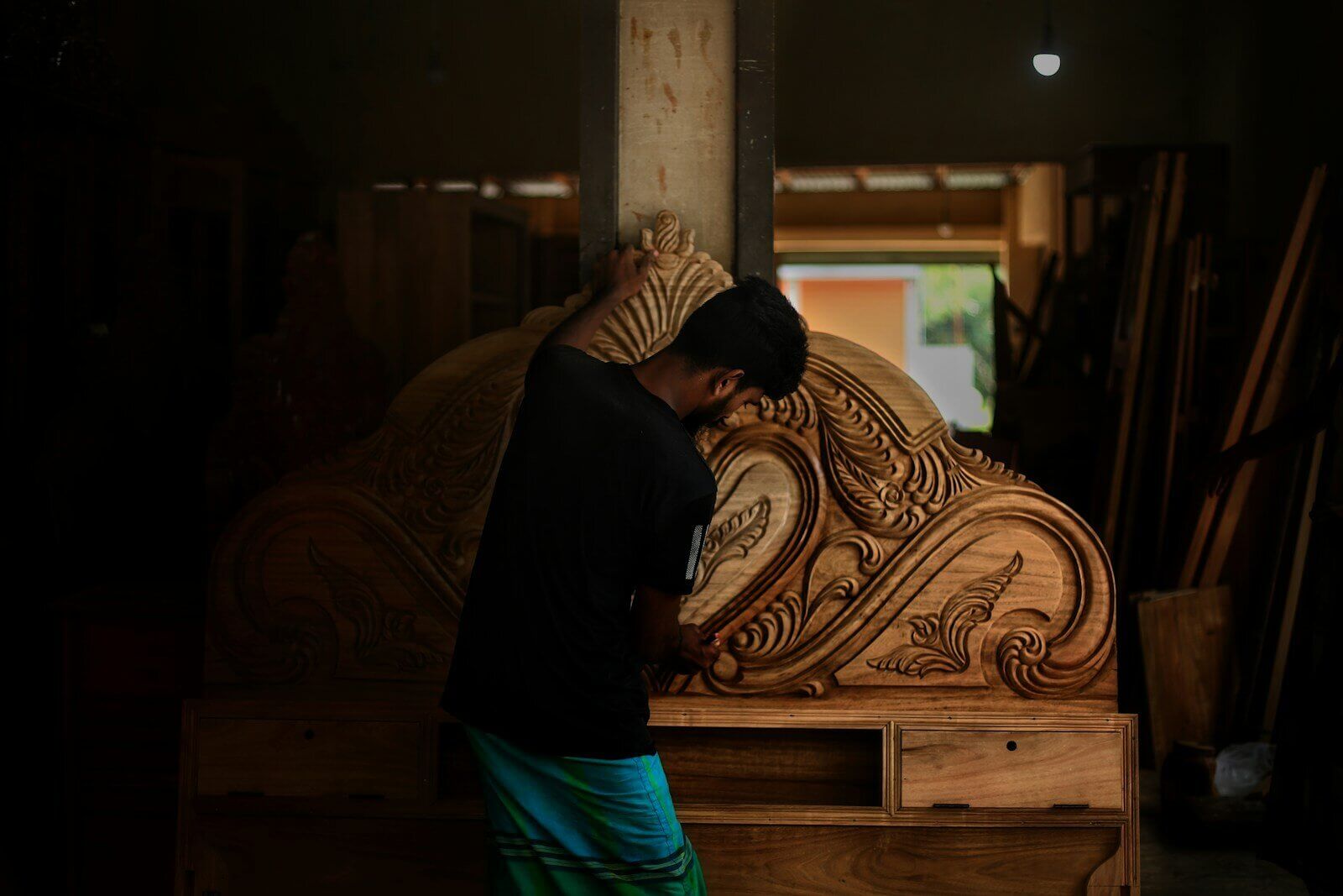 A man standing next to a large wooden object